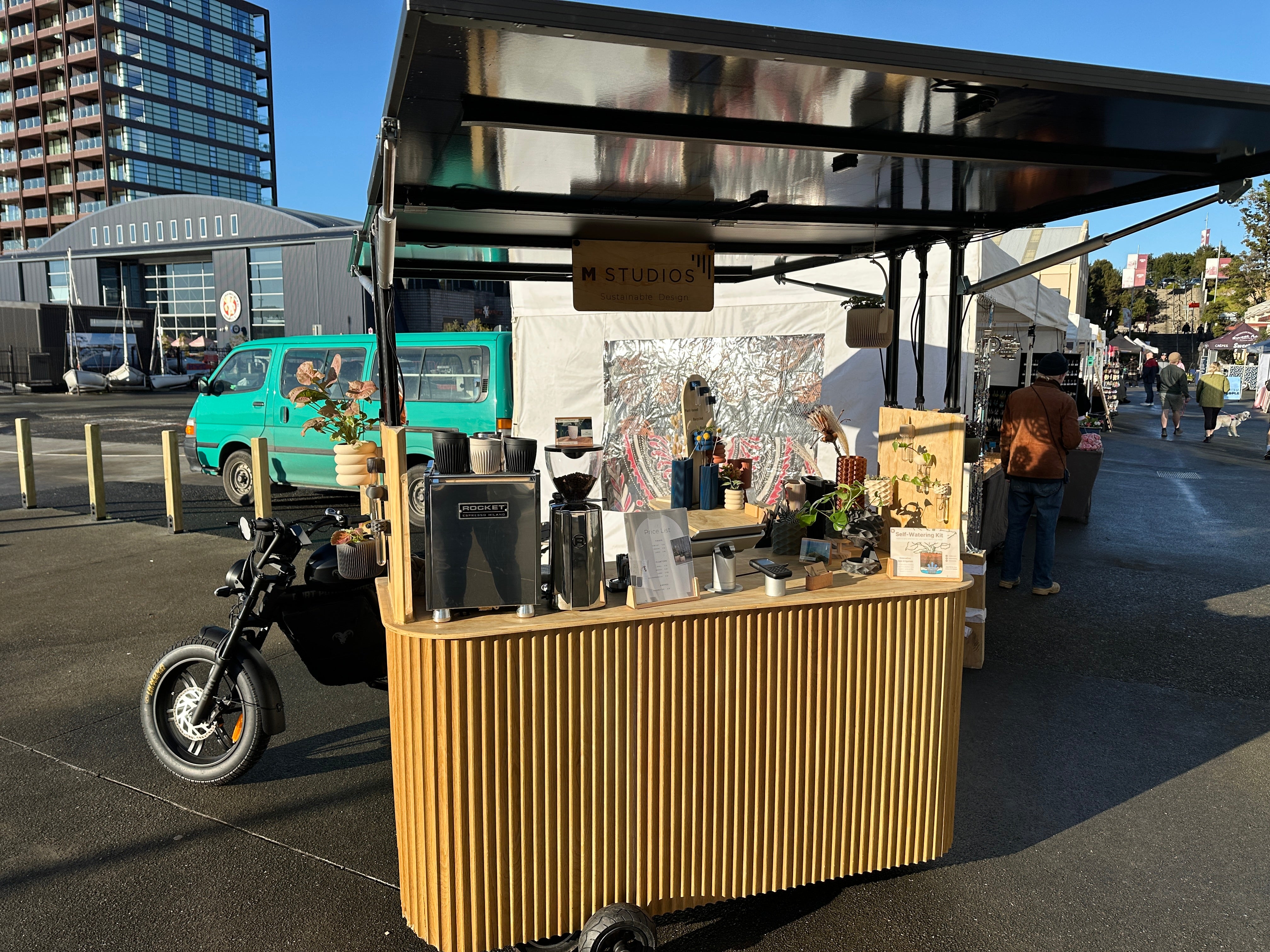 Outdoor market stall with various items on a sunny day
